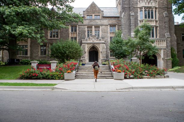 A shot of a student walking up the University Hall steps on campus