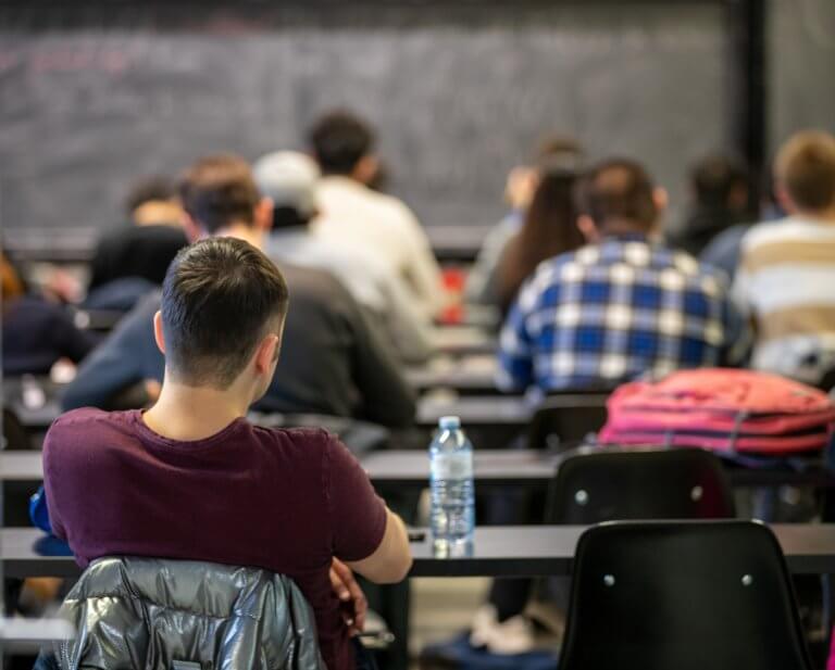 A back-shot of a classroom full of students during a lecture