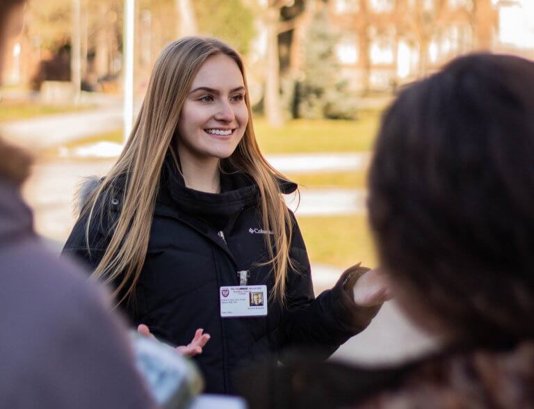 A McMaster student tour guide leading a campus tour