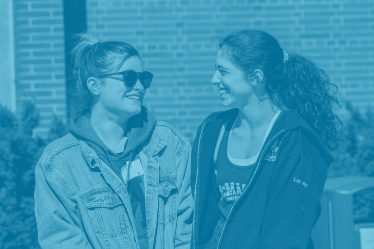 A blue green duotone image of two McMaster university students standing together for a picture on campus