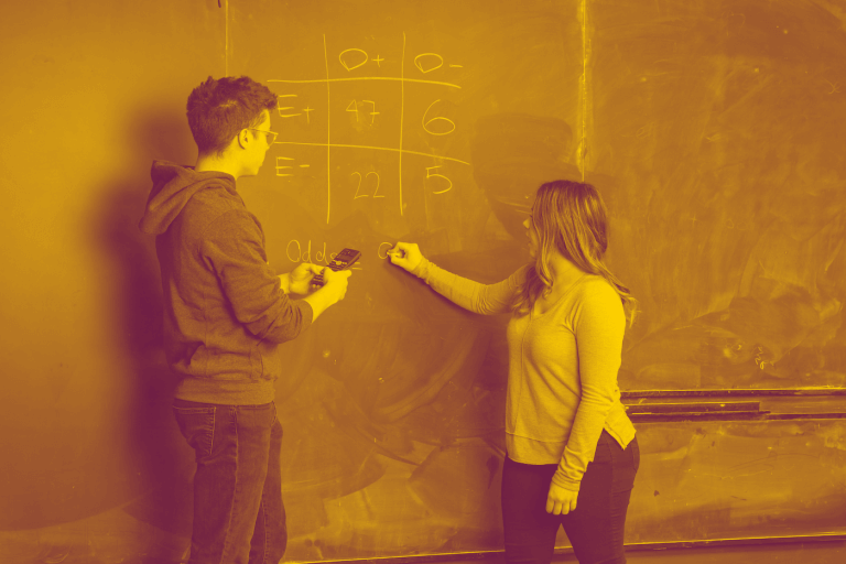 A maroon and yellow duotone image of two students solving an equation on a chalkboard