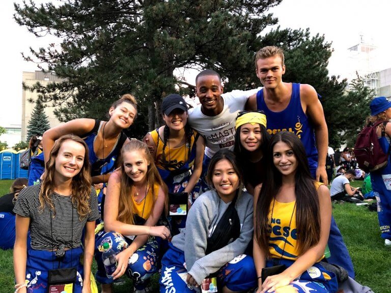 A group of McMaster students representing their faculty, posing in BSB field