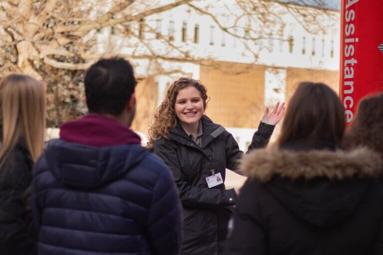 Student tour guide showing people around McMaster campus